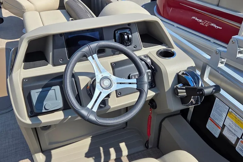 Slide: The Image of 2025 Sun Tracker Sportfish 24 XP3 boat dashboard with steering wheel and controls. - 4