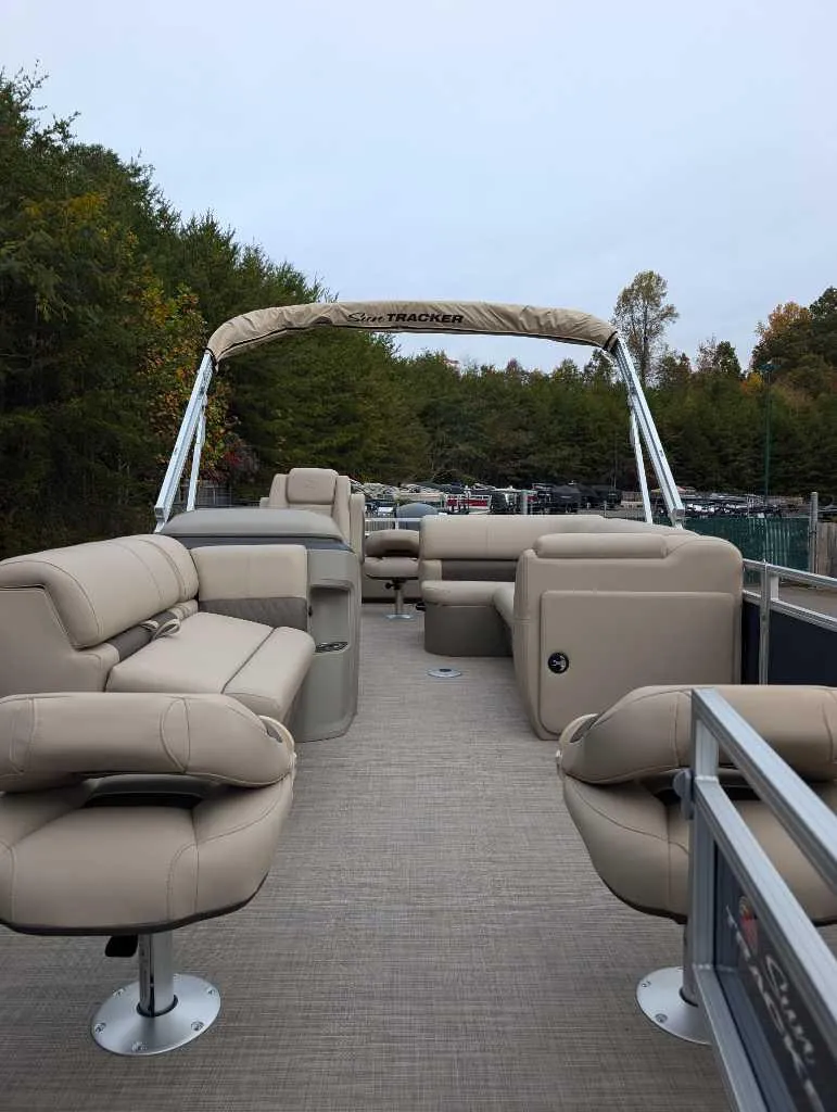 Slide: The Image of 2025 Sun Tracker Fishin' Barge 22 DLX pontoon boat with beige seating and canopy. - 3