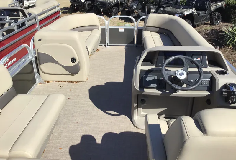 Slide: The Image of 2025 Sun Tracker Party Barge 18 DLX interior with beige seating and steering console. - 3