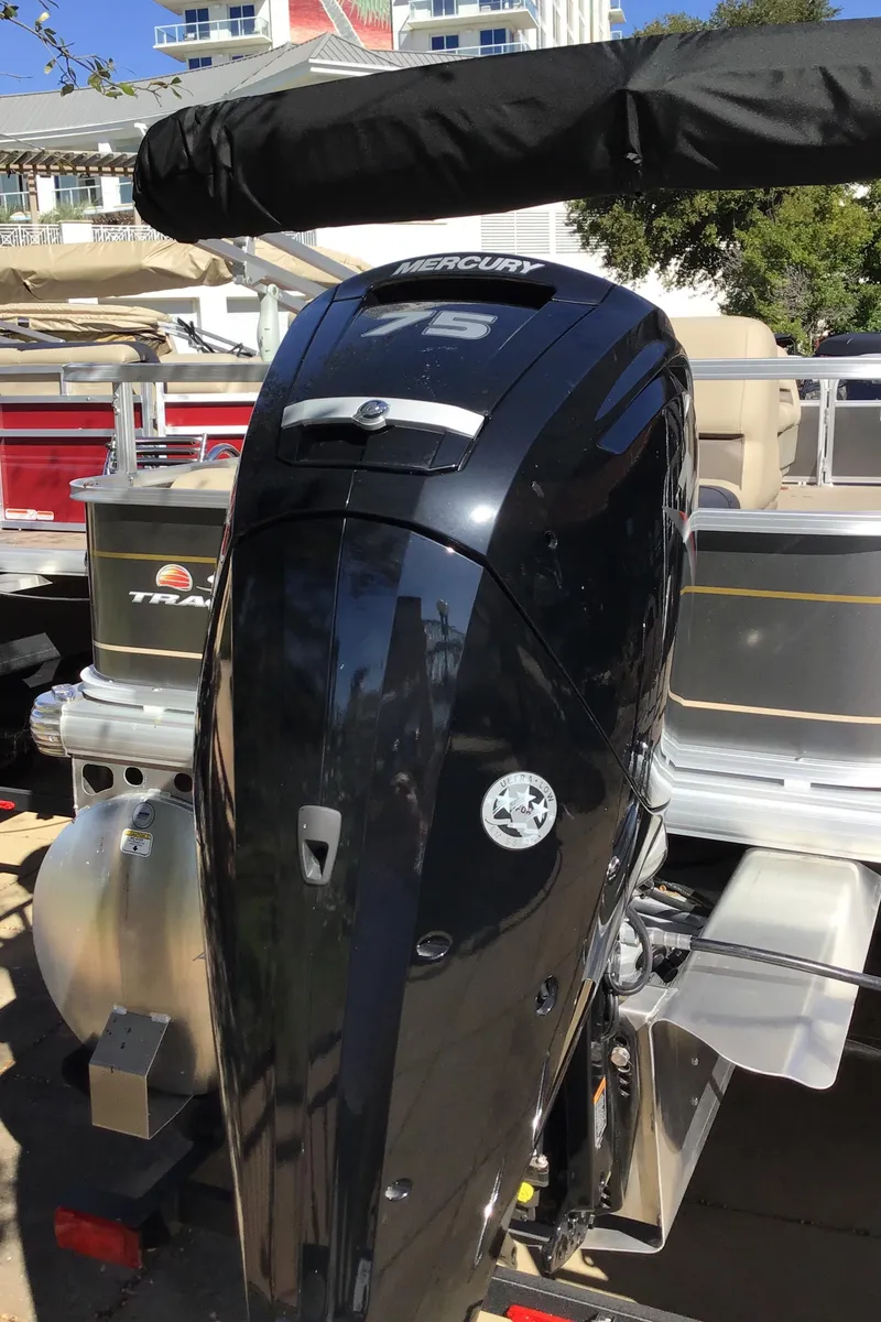 Slide: The Image of 2025 Sun Tracker Party Barge 18 DLX with Mercury outboard motor, docked outdoors. - 4