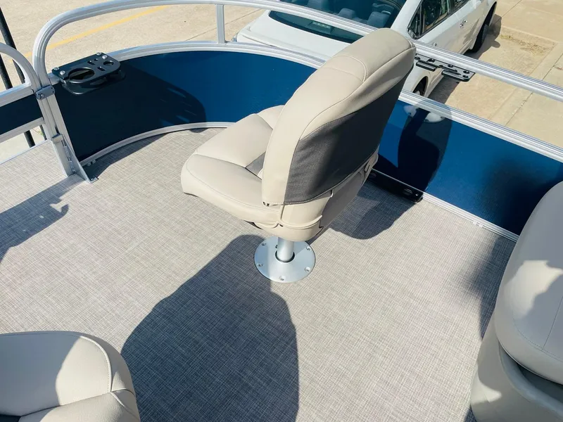 Slide: The Image of 2025 Sun Tracker Bass Buggy 16 XL Select boat interior with beige seating and blue railing. - 12