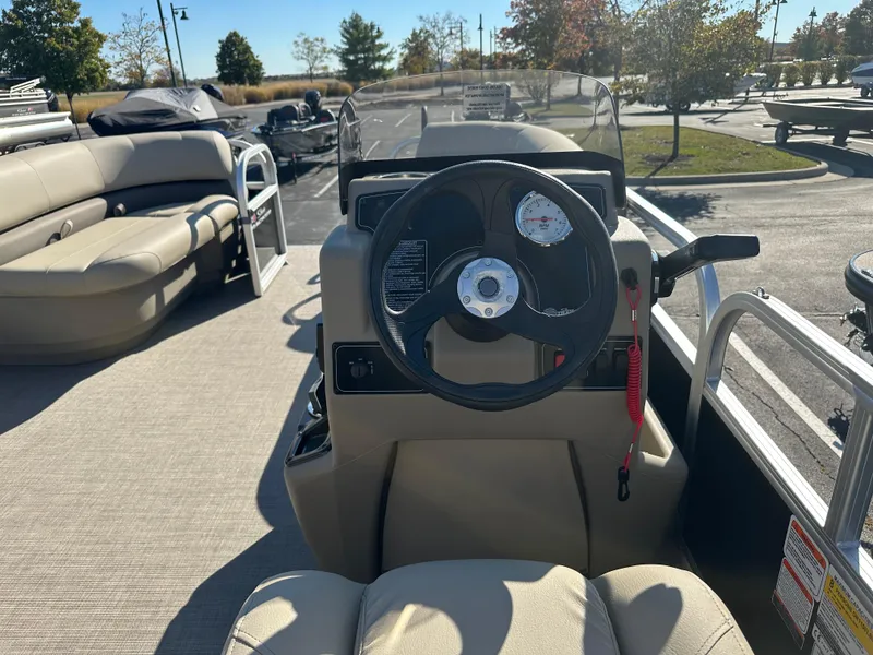 Slide: The Image of 2025 Sun Tracker Party Barge 16 DLX interior with steering wheel and seating. - 2
