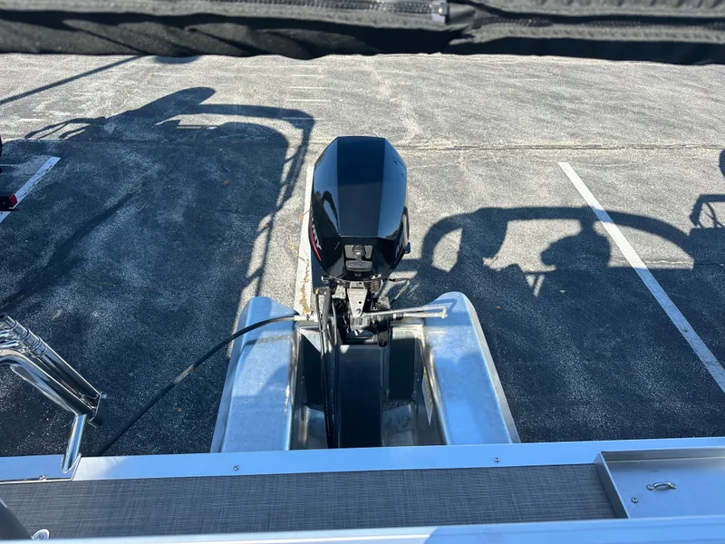 Slide: The Image of 2025 Sun Tracker Party Barge 16 DLX with outboard motor in parking lot. - 6