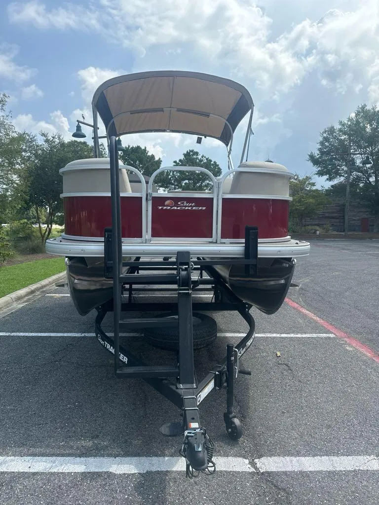 Slide: The Image of 2025 Sun Tracker Party Barge 18 DLX pontoon boat on trailer in parking lot. - 3