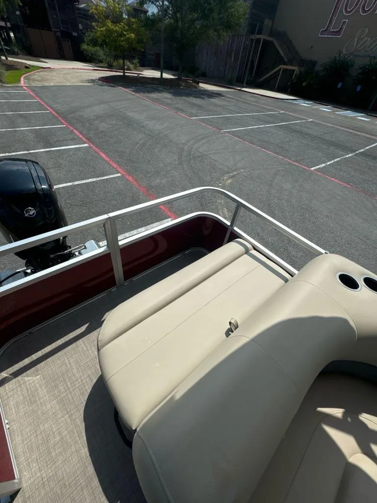 Slide: The Image of 2025 Sun Tracker Party Barge 18 DLX in parking lot, rear seating view. - 7