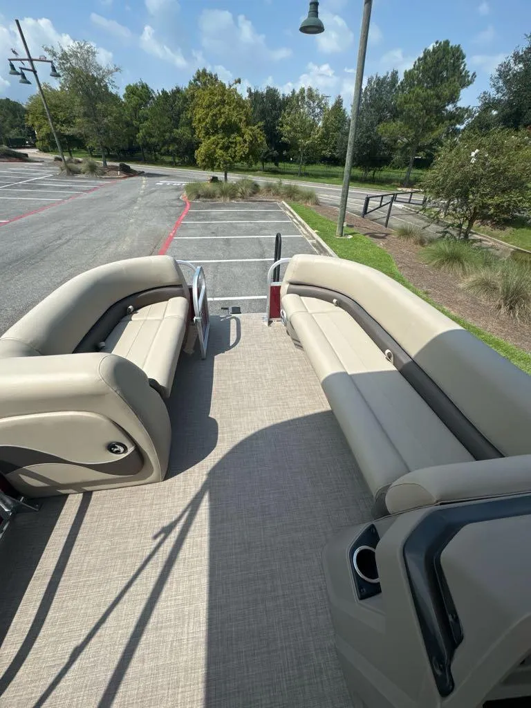 Slide: The Image of 2025 Sun Tracker Party Barge 18 DLX with spacious seating, parked outdoors. - 8