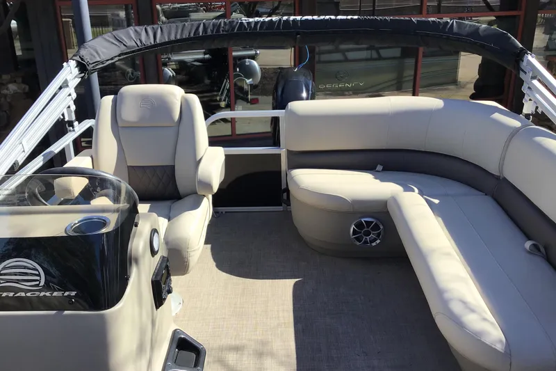 Slide: The Image of 2025 Sun Tracker Party Barge 16 DLX interior with plush seating and steering console. - 2