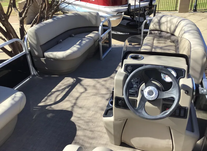 Slide: The Image of 2025 Sun Tracker Party Barge 16 DLX interior with seating and steering console. - 3