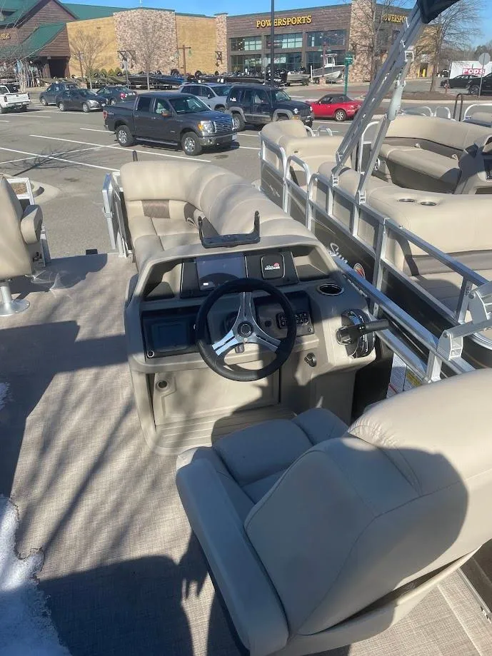Slide: The Image of 2025 Sun Tracker SportFish 20 DLX pontoon boat interior with steering wheel and seating. - 3