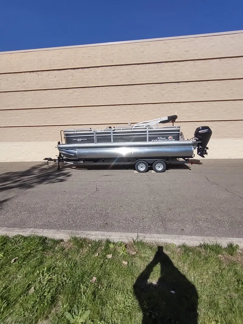 The Image of 2025 Sun Tracker Party Barge 22 RF DLX pontoon boat parked on trailer. - 0