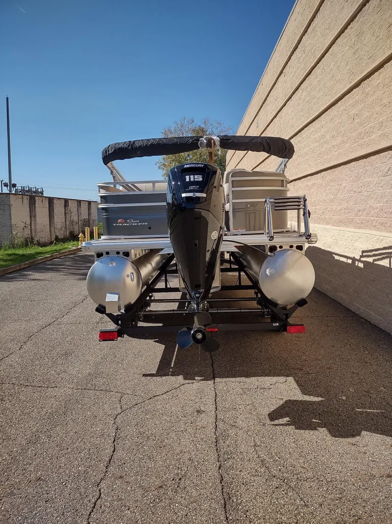 Slide: The Image of 2025 Sun Tracker Party Barge 22 RF DLX pontoon boat, rear view, parked outdoors. - 5