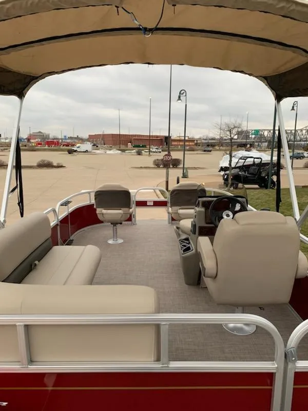 Slide: The Image of 2025 Sun Tracker Bass Buggy 16 XL Select pontoon boat with beige seating and canopy. - 2