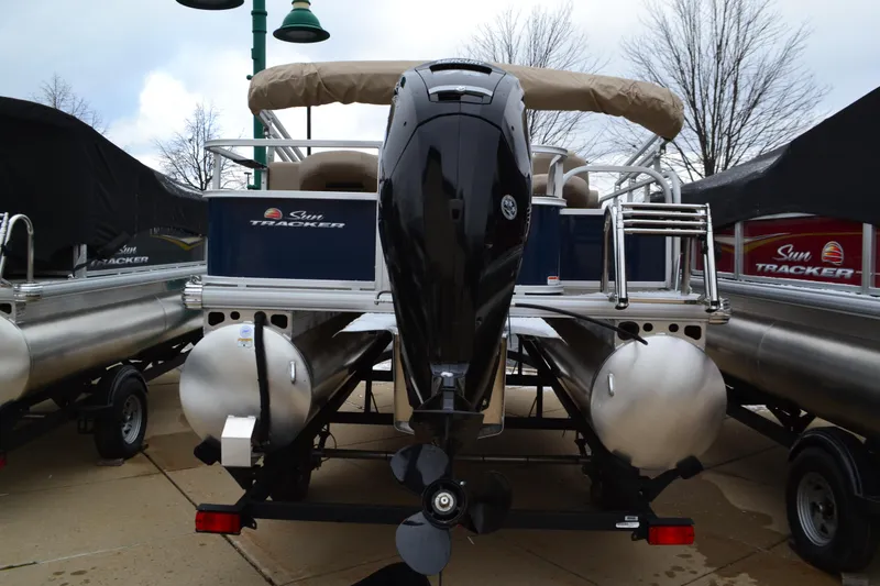 Slide: The Image of 2025 Sun Tracker Bass Buggy 18 DLX pontoon boat, rear view with motor and pontoons. - 2