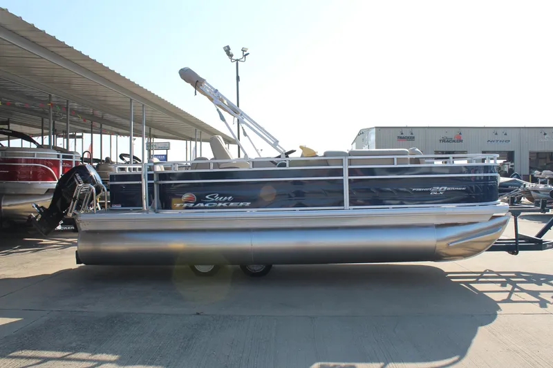 The Image of 2025 Sun Tracker Fishin' Barge 20 DLX pontoon boat in a marina setting. - 0