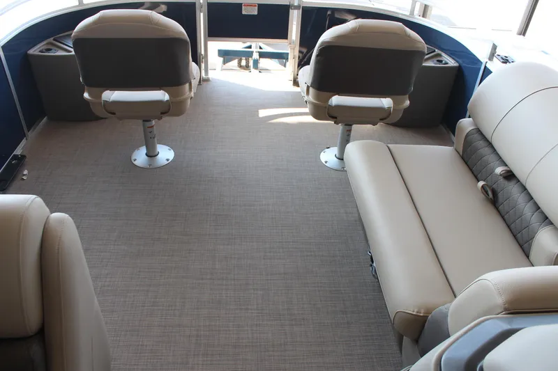 Slide: The Image of 2025 Sun Tracker Fishin' Barge 20 DLX interior with beige seating and carpet. - 10