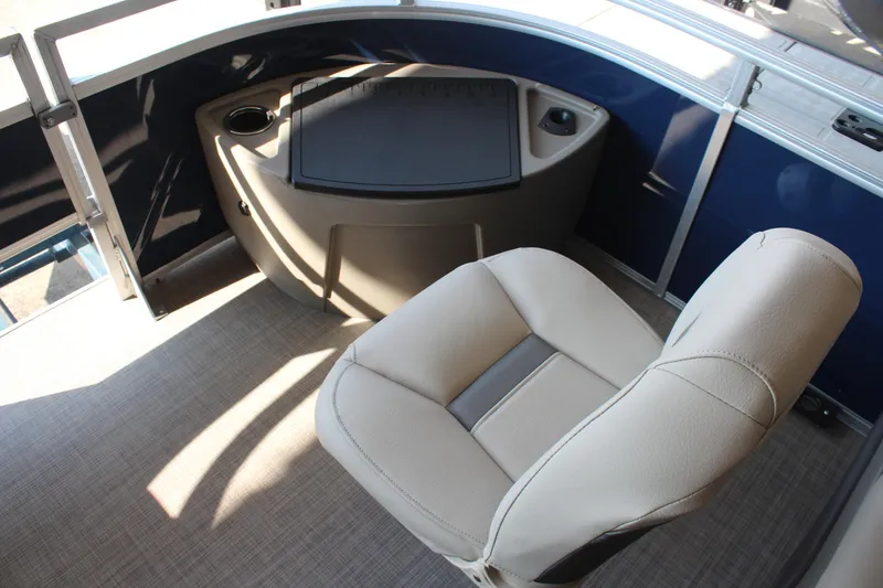 Slide: The Image of 2025 Sun Tracker Fishin' Barge 20 DLX interior with beige captain's chair and control panel. - 12