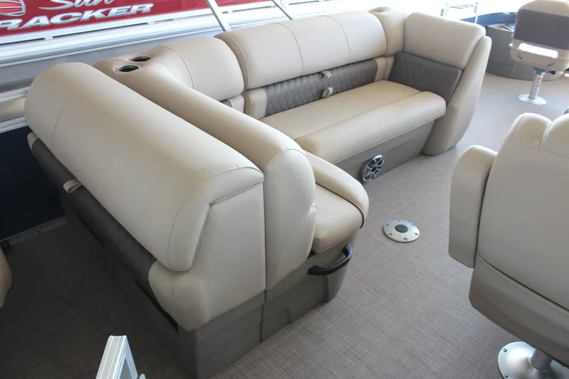 Slide: The Image of 2025 Sun Tracker Fishin' Barge 20 DLX interior with beige seating and cup holders. - 7