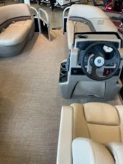 Slide: The Image of 2025 Sun Tracker Party Barge 16 DLX interior with beige seating and steering console. - 43