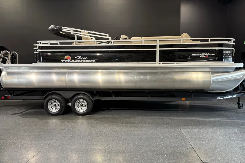 The Image of 2025 Sun Tracker Sportfish 24 XP3 pontoon boat on trailer in showroom. - 0
