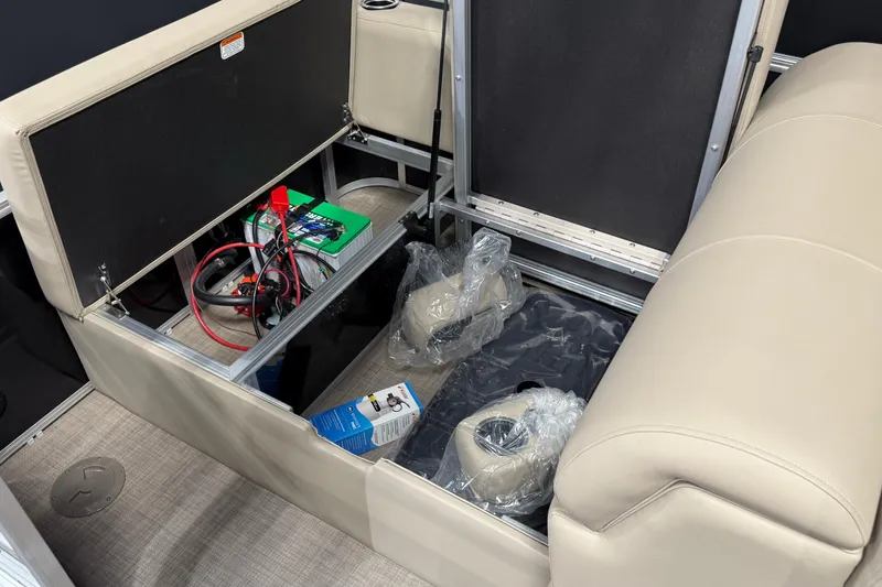 Slide: The Image of Open storage compartment in 2025 Sun Tracker Sportfish 24 XP3 boat, revealing battery and accessories. - 10