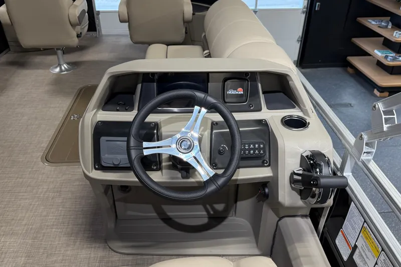 Slide: The Image of 2025 Sun Tracker Sportfish 24 XP3 boat console with steering wheel and controls. - 14