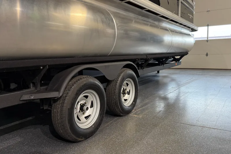 Slide: The Image of 2025 Sun Tracker Sportfish 24 XP3 pontoon boat on trailer in garage. - 29