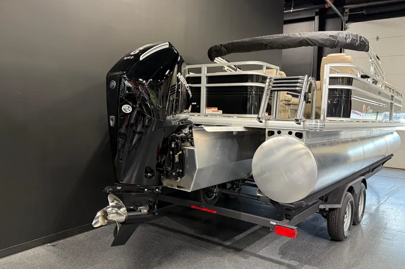 Slide: The Image of 2025 Sun Tracker Sportfish 24 XP3 pontoon boat with powerful outboard motor in showroom. - 3