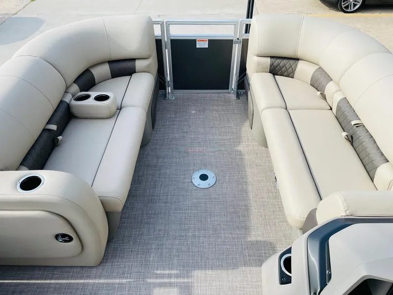 Slide: The Image of 2025 Sun Tracker Party Barge 22 RF DLX interior with beige seating and cup holders. - 10