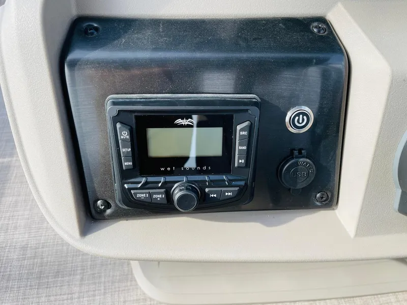 Slide: The Image of 2025 Sun Tracker Party Barge 22 RF DLX audio control panel with display and power button. - 26