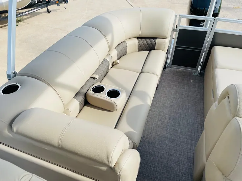 Slide: The Image of 2025 Sun Tracker Party Barge 22 RF DLX interior with beige seating and cup holders. - 29