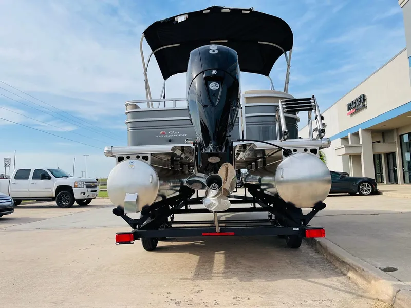 Slide: The Image of 2025 Sun Tracker Party Barge 22 RF DLX pontoon boat, rear view, parked outdoors. - 7