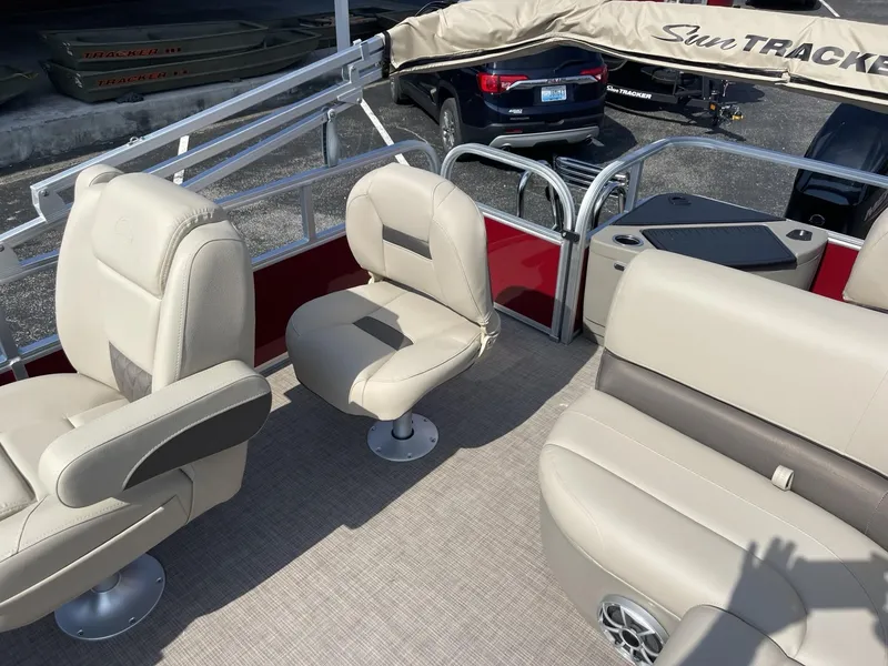 Slide: The Image of 2025 Sun Tracker Bass Buggy 18 DLX pontoon boat interior with beige seating and red accents. - 9