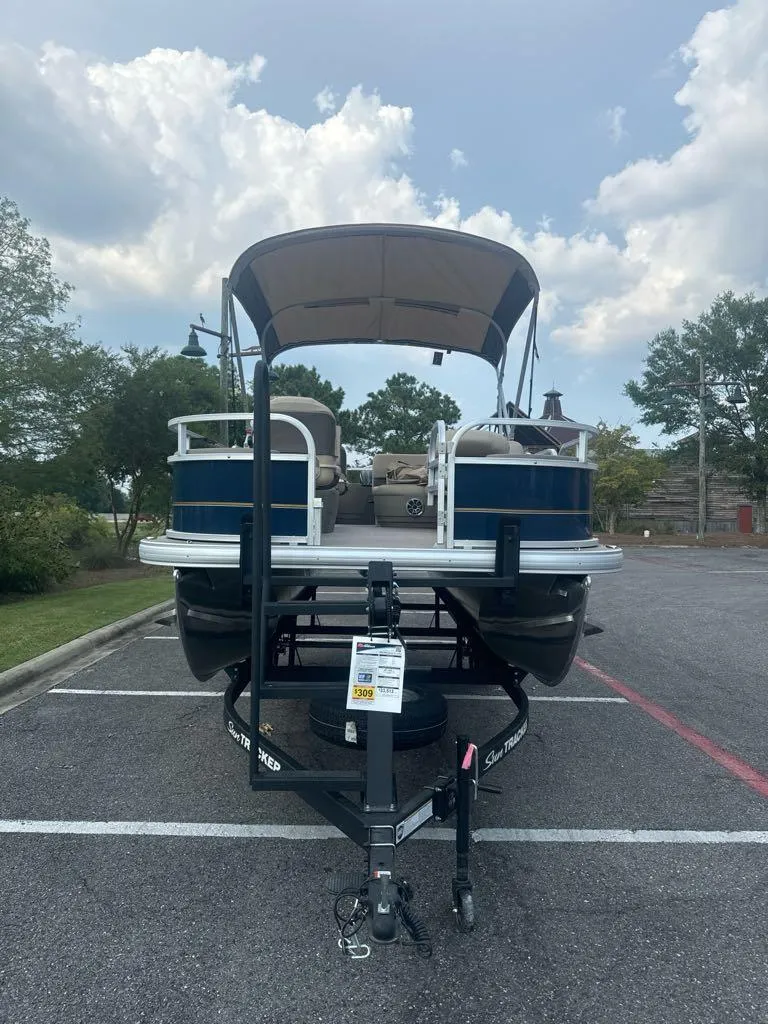 Slide: The Image of 2025 Sun Tracker Bass Buggy 18 DLX pontoon boat in parking lot. - 3