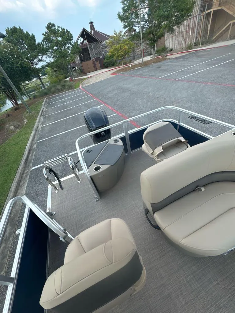 Slide: The Image of 2025 Sun Tracker Bass Buggy 18 DLX pontoon boat in parking lot. - 6