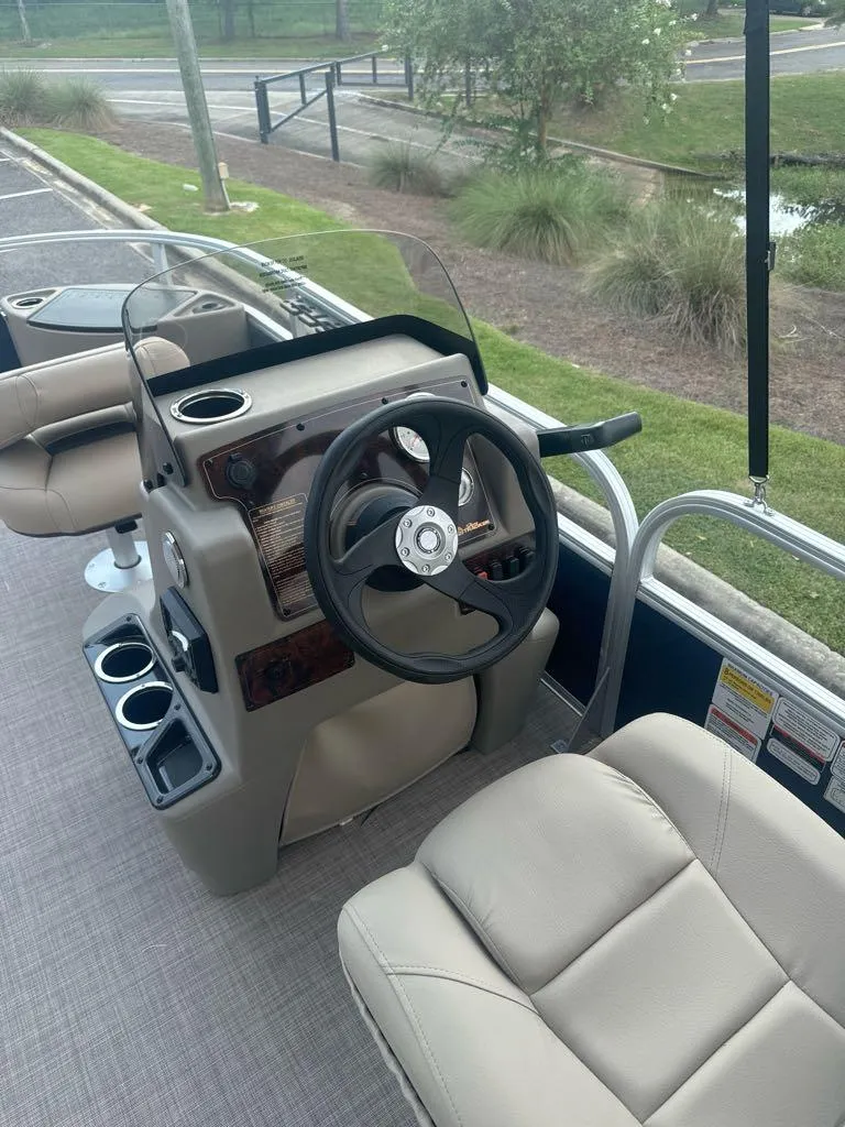Slide: The Image of 2025 Sun Tracker Bass Buggy 18 DLX pontoon boat interior with steering console and seating. - 7