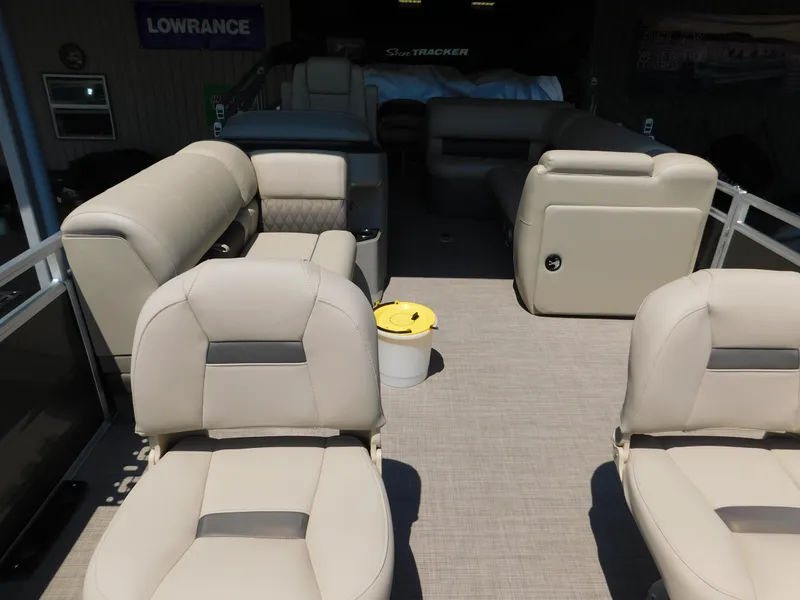 Slide: The Image of 2025 Sun Tracker Fishin' Barge 22 DLX interior with beige seating and spacious layout. - 10