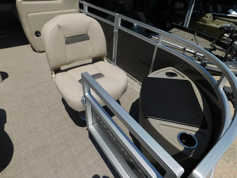 Slide: The Image of 2025 Sun Tracker Fishin' Barge 22 DLX interior with beige seating and fishing station. - 30
