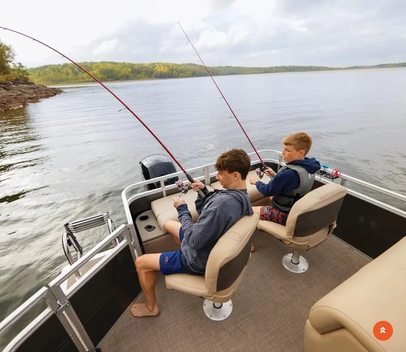 Slide: The Image of Two people fishing on a 2025 Sun Tracker Fishin' Barge 22 DLX pontoon boat. - 36