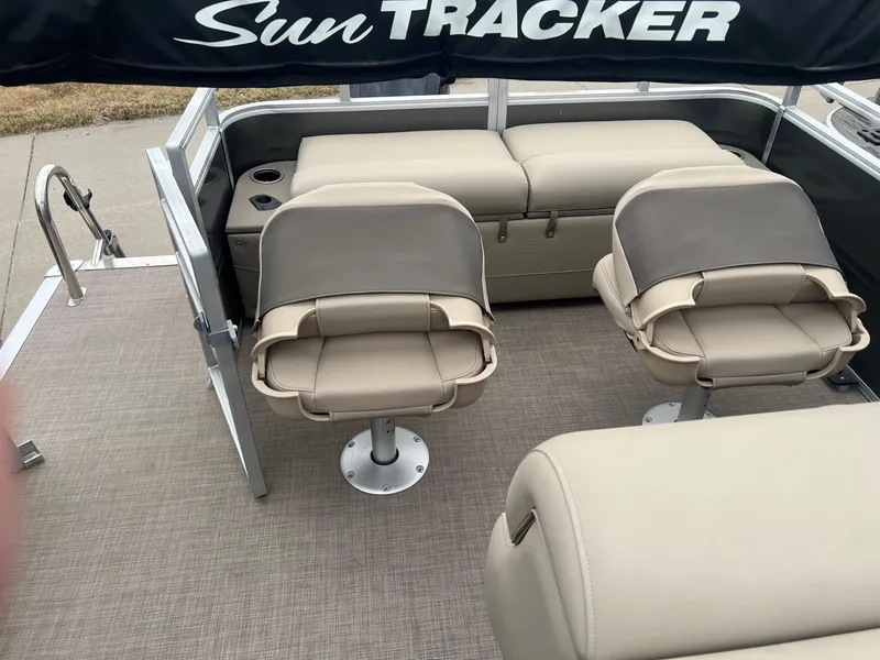 Slide: The Image of 2025 Sun Tracker Fishin' Barge 22 XP3 interior with beige seating and cup holders. - 3
