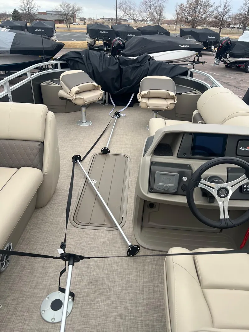 Slide: The Image of 2025 Sun Tracker Fishin' Barge 22 XP3 interior with seating and steering console. - 4