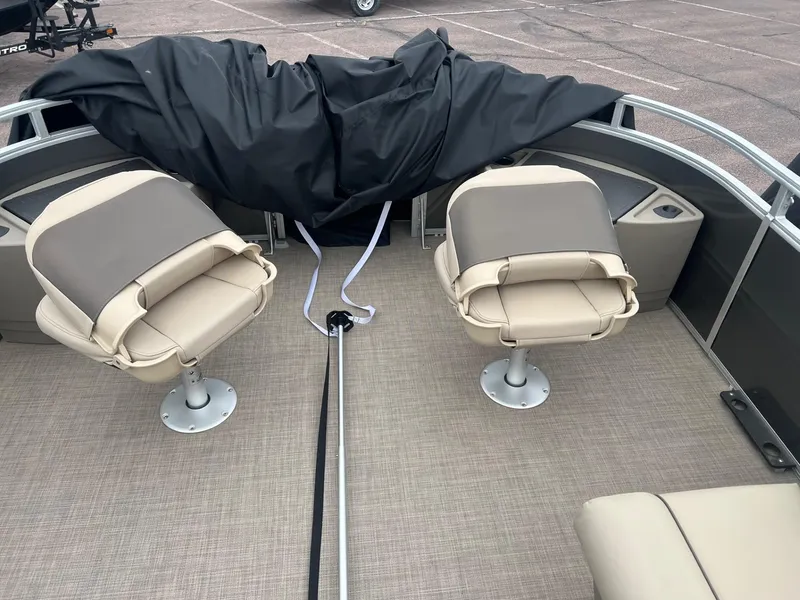 Slide: The Image of 2025 Sun Tracker Fishin' Barge 22 XP3 interior with two swivel seats and covered console. - 6