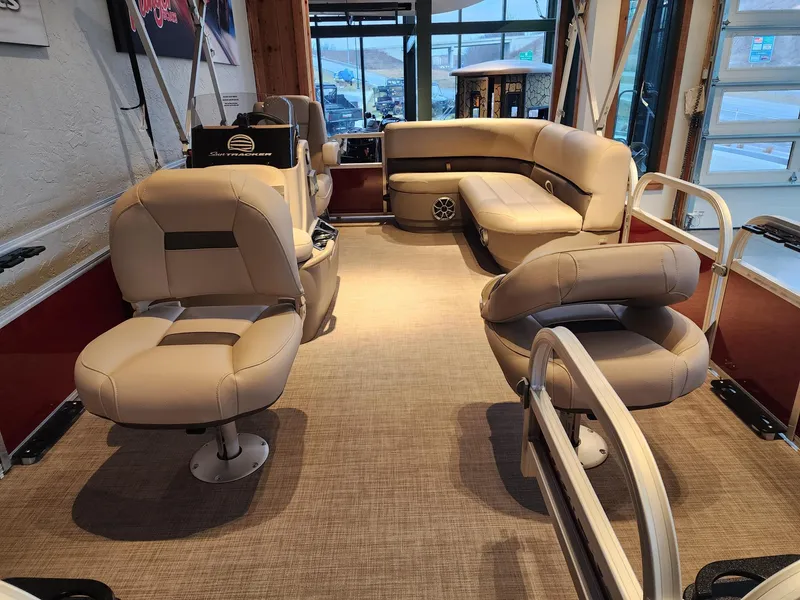 Slide: The Image of Interior of 2025 Sun Tracker Bass Buggy 16 XL Select pontoon boat with beige seating. - 2