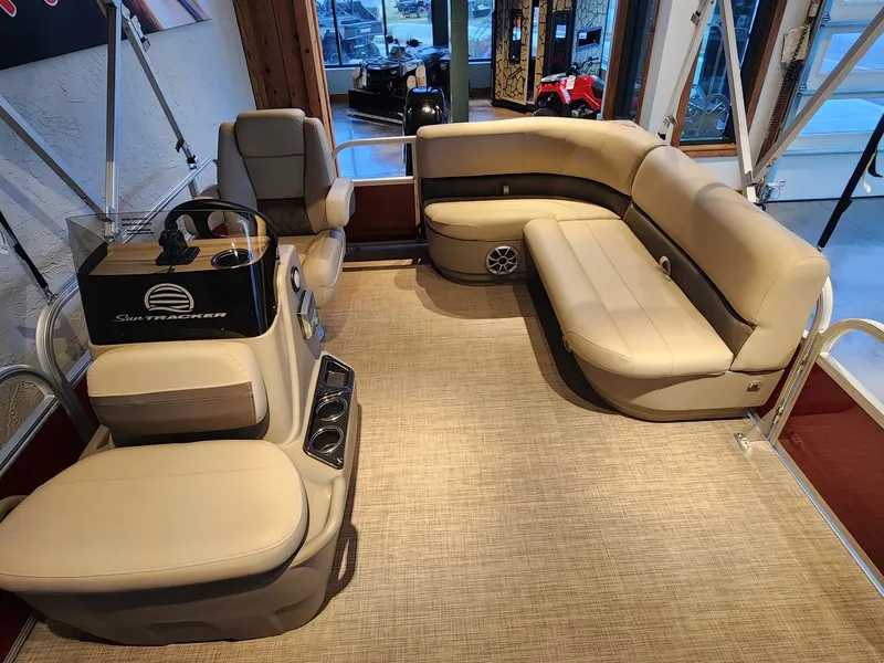 Slide: The Image of 2025 Sun Tracker Bass Buggy 16 XL Select interior with beige seating and steering console. - 3