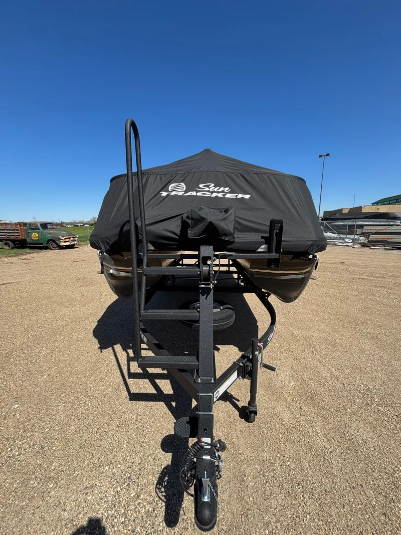 Slide: The Image of 2025 Sun Tracker Bass Buggy 16 XL Select on trailer, covered, parked outdoors. - 11
