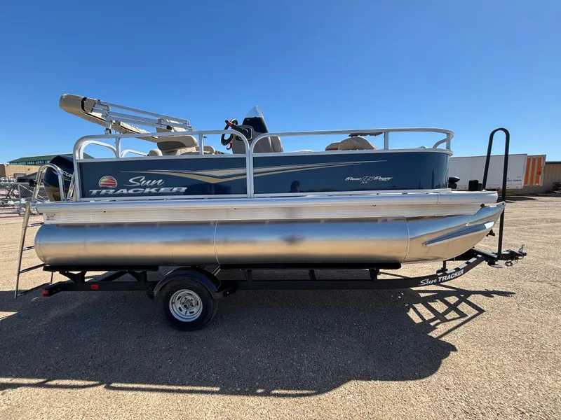 Slide: The Image of 2025 Sun Tracker Bass Buggy 16 XL Select pontoon boat on trailer, side view. - 3