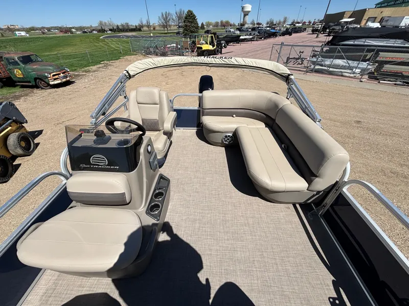 Slide: The Image of 2025 Sun Tracker Bass Buggy 16 XL Select pontoon boat with beige seating and steering console. - 7