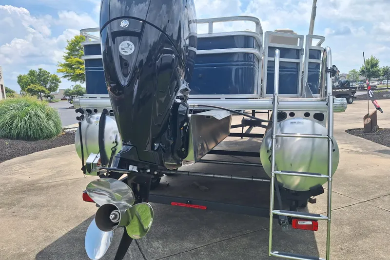 Slide: The Image of 2025 Sun Tracker Fishin' Barge 22 DLX pontoon boat rear view with motor and ladder. - 6