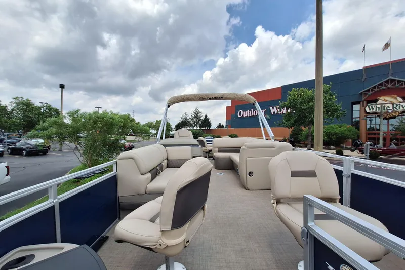 Slide: The Image of 2025 Sun Tracker Fishin' Barge 22 DLX pontoon boat at Outdoor World parking lot. - 2