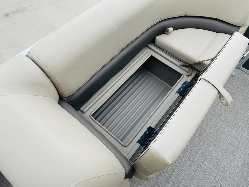 Slide: The Image of 2025 Sun Tracker Party Barge 18 DLX storage compartment with beige seating. - 11