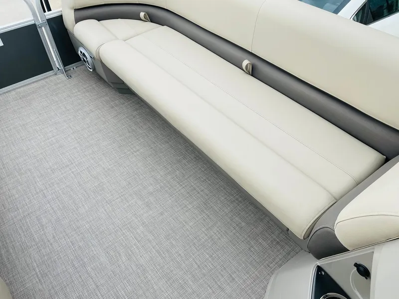 Slide: The Image of 2025 Sun Tracker Party Barge 18 DLX interior with beige seating and carpeted floor. - 13
